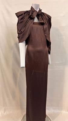 une photo d'un mannequin portant une robe marron ornée d'un grand nœud sur l'épaule