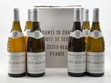 three bottles of white wine sitting next to each other in front of a box