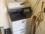 a plant in a pot next to a printer on the floor