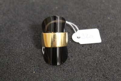 une bague noire et dorée, ornée d'un anneau doré