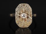 une bague en or et diamants sur une surface noire