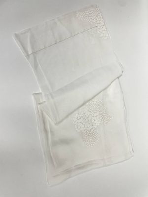 deux serviettes blanches posées sur une table blanche, sur fond blanc