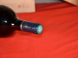 a bottle of wine sitting on a red table cloth