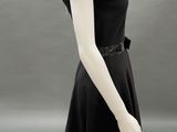 a mannequin wearing a black dress with sequins on the shoulders