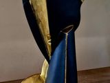a blue and gold sculpture of a man ' s head on a wooden table