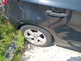 a black car with a flat tire parked on the side of the road