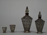 three silver vases sitting next to each other on a table
