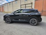 a black suv parked in a parking lot next to a building