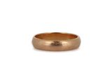 a close up of a gold wedding ring on a white background