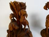 two wooden sculptures of animals on display on a table