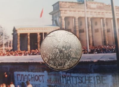 une photo d'une pièce de monnaie avec, en arrière-plan, l'image d'un bâtiment