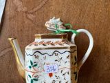 a teapot with a tag on it sitting on a table