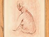 une image représentant un dessin d'une femme nue assise, dans un cadre en bois
