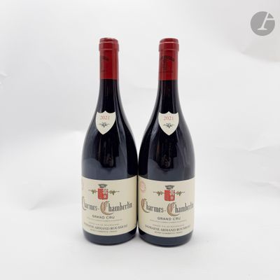deux bouteilles de vin rouge posées l'une à côté de l'autre sur une surface blanche