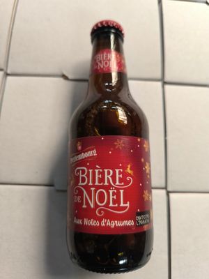 une bouteille de bière posée sur un sol carrelé