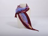 purple and red scarf on a mannequin stand on a white surface