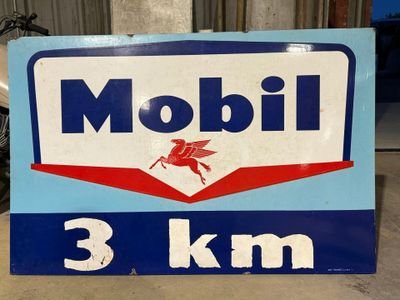 un panneau indiquant « Mobil à 3 km » au bord de la route
