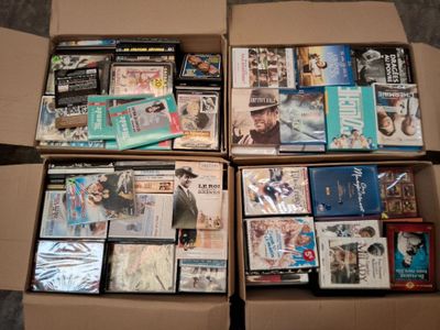 un grand nombre de dvd dans une boîte posée sur le sol