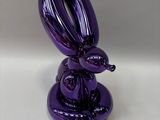 a purple balloon shaped like a rabbit sitting on top of a plate