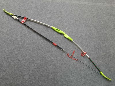 a close up of a green and black bow on a gray surface
