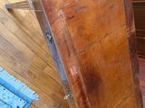 a wooden cabinet sitting on a wooden floor next to a blue rug
