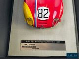 a red and yellow car on display in a glass case