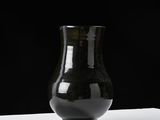 a black vase that is sitting on a white table