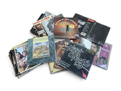 une pile de CD de toutes sortes posée sur une surface blanche