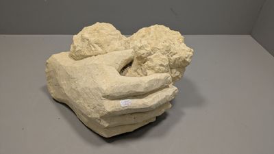 une sculpture représentant une main tenant un bébé dans ses bras