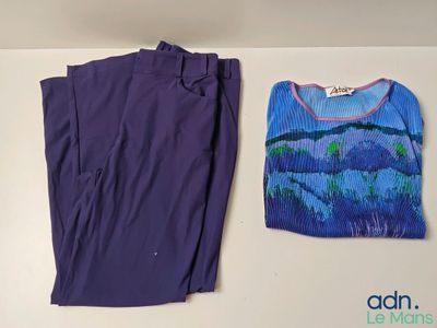 Un pantalon violet et un t-shirt sont posés sur une table