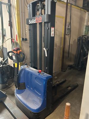 a forklift in a garage with a blue seat