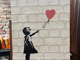 painting of a girl with a red balloon on a brick wall