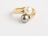 Gros plan sur une bague en or ornée de deux perles