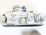 a close up of a silver camera with a white background