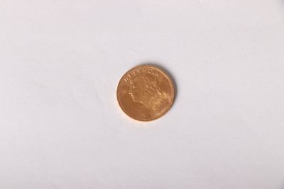 a small coin on a white surface with a white background