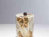 a white vase with a yellow flower on it