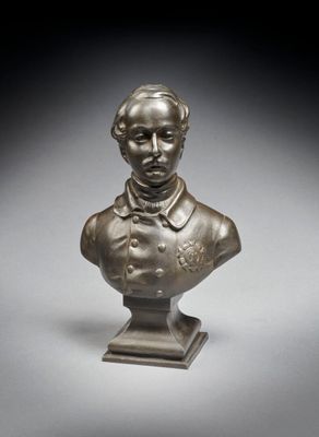 un buste en bronze représentant un homme en costume-cravate