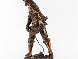 an image of a bronze statue of a man with a gun