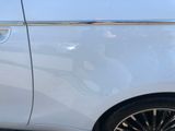 a white car with black rims parked on the side of the street