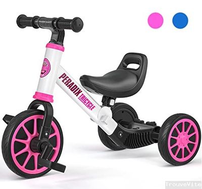 un tricycle rose et blanc à côté d'un ballon bleu et rose