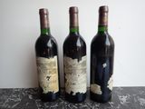 three bottles of wine that are sitting on a table