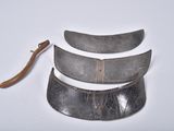 several pieces of metal are sitting on a white surface next to a knife