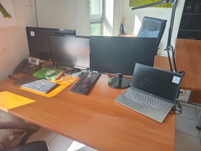 a desk with two computers and a laptop on it