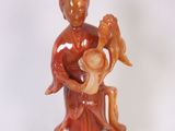 une figurine représentant une femme tenant un bébé et un oiseau