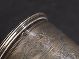 a close up of a silver vase on a black background