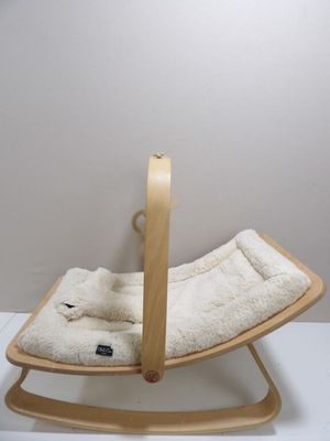 a wooden rocking chair with a white blanket on it