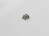 a green tourmaline stone on a white surface