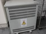 une armoire métallique sur laquelle est accrochée une pancarte, à côté d'une cage grillagée