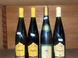 four bottles of wine are lined up on a shelf in a cabinet