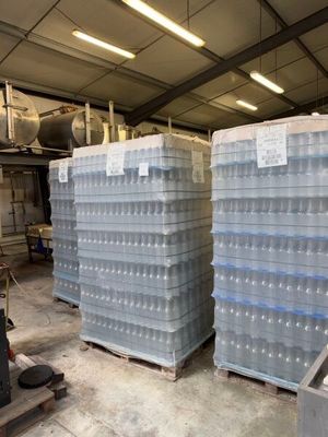 several stacks of plastic water bottles stacked on pallets in a warehouse